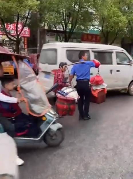 老奶奶路邊「擺攤賣菜放錯位置」暖心城管「挑擔牽手」找個暖和攤位 網贊:非常的有溫度的執法