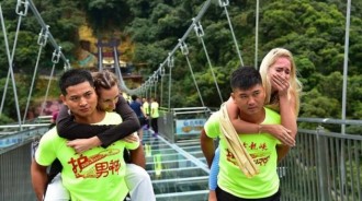 玻璃橋上的新職業，大家稱他們為「護玻男神」專門背女遊客過橋的